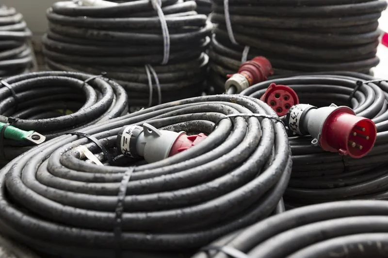 Coiled power cables with red industrial plugs
