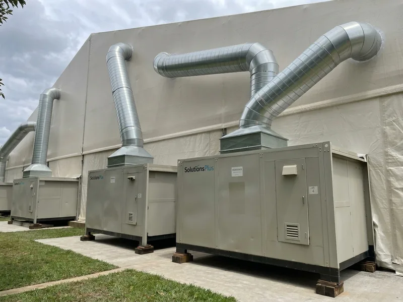 Ducted generator units beside a large tent venue