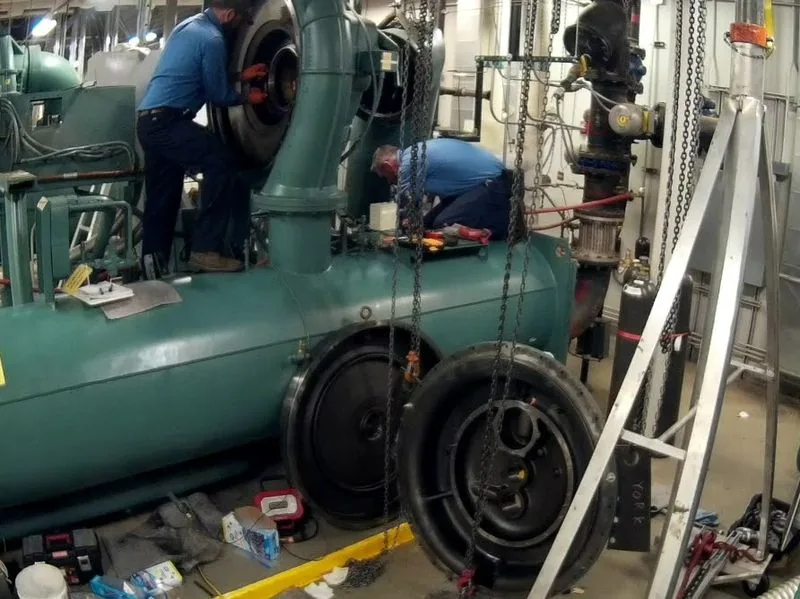 Technicians overhauling a water-cooled chiller on site